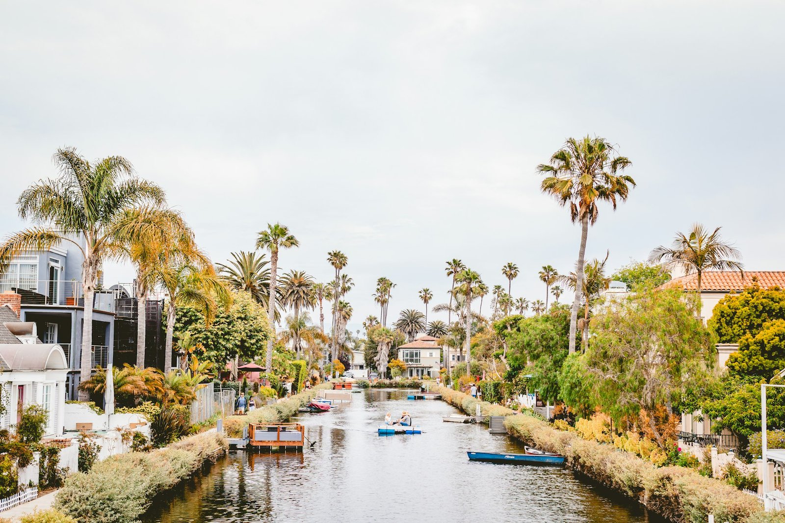 Palm trees and small boats along a Venice canal in Los Angeles